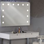 Makeup vanity: white dressing table, lighted mirror and white makeup chair